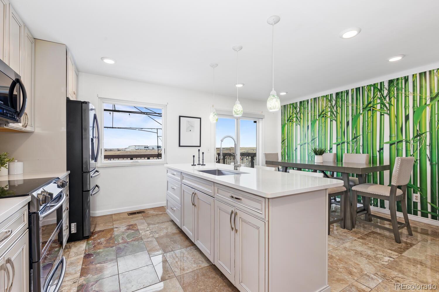 Bright kitchen with a large white island, stainless steel appliances, and a bamboo-patterned dining wall.