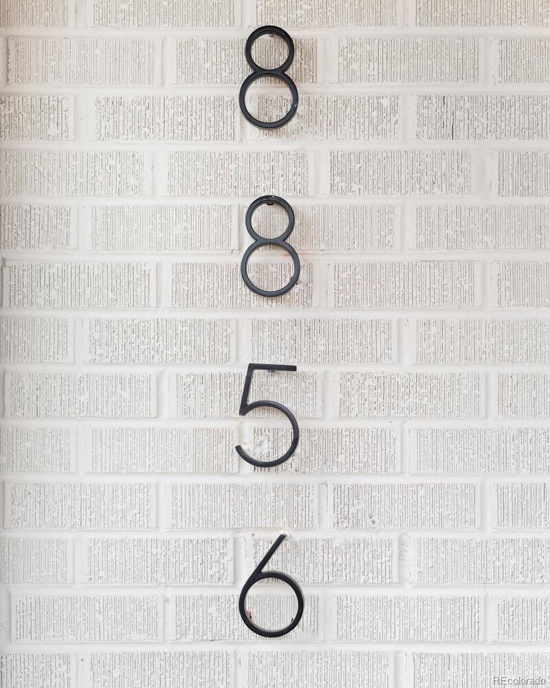 House number 8856 mounted on a white brick exterior wall.