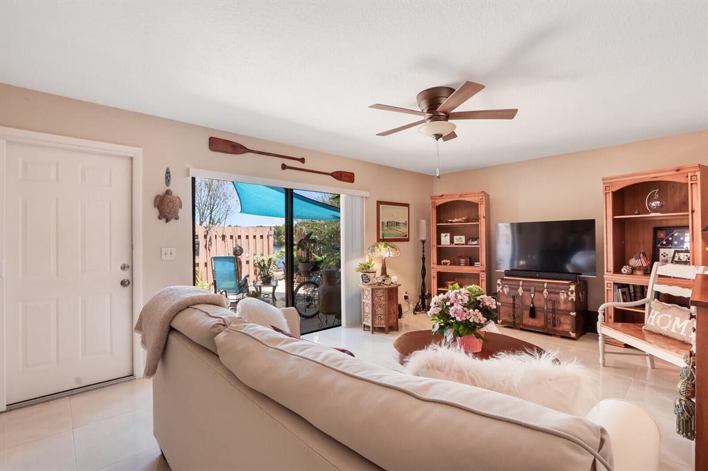 Living room with leather sofa, wooden media furniture, and sliding glass doors to a patio.
