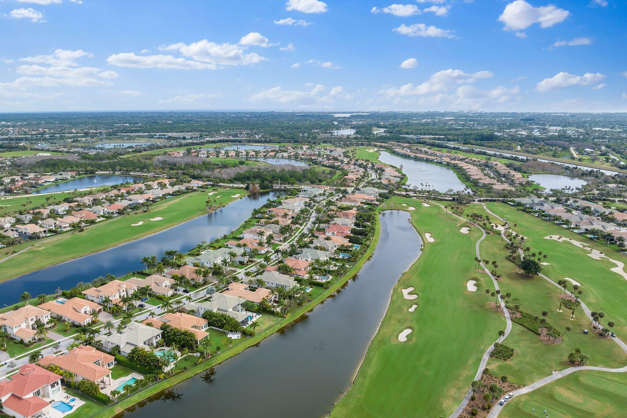 Aerial view of homes along a lake beside a golf course.