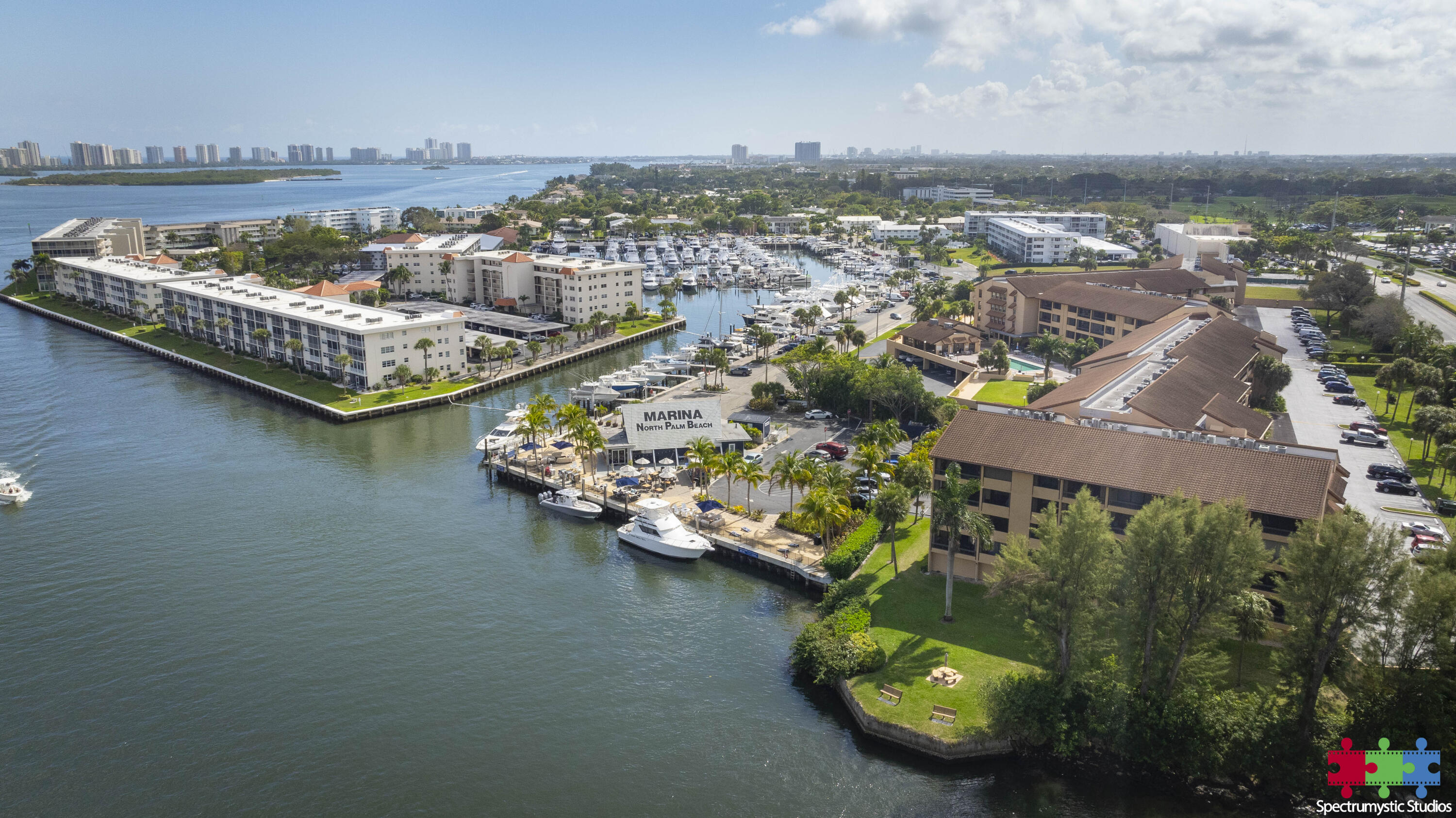 Aerial view of waterfront condominiums and North Palm Beach marina, with boats docked along the waterways.