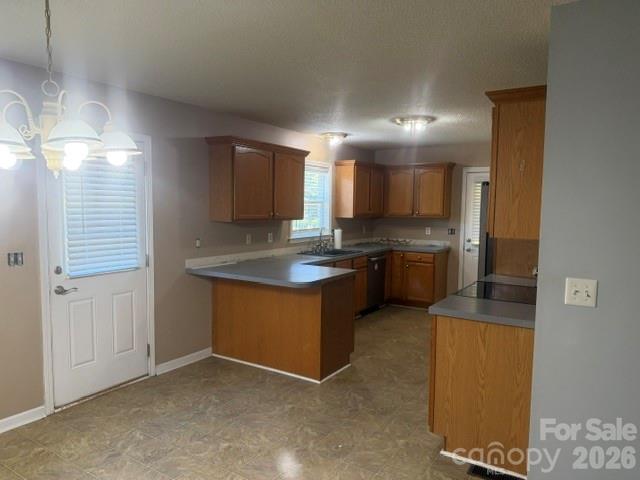Vacant kitchen with wood cabinets, a central island, and gray countertops.
