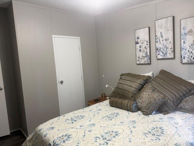 Bedroom with patterned bedding, layered pillows, and framed botanical prints.