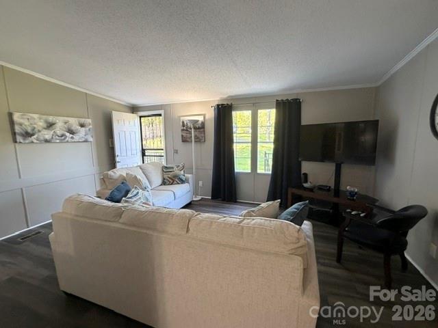 Living room with cream sofas, a television, and a window overlooking a green lawn.