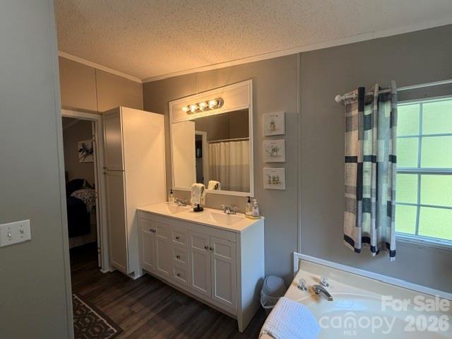 Bathroom with a long white vanity, double sinks, and a bathtub beside a curtained window.