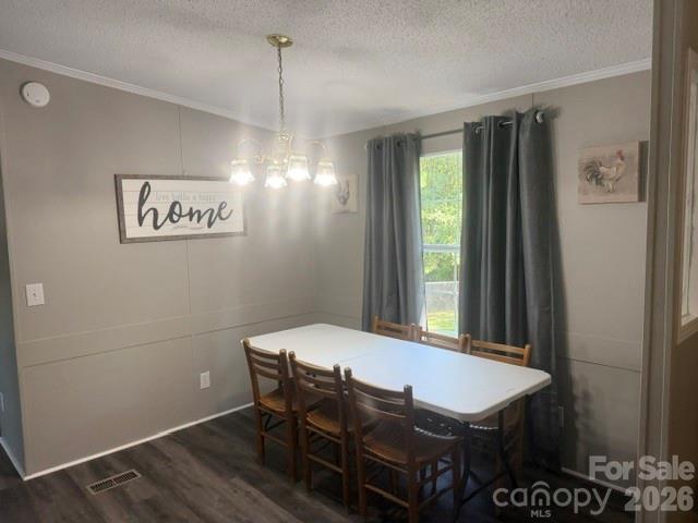 Dining room with a white table, wooden chairs, chandelier, and gray curtains.
