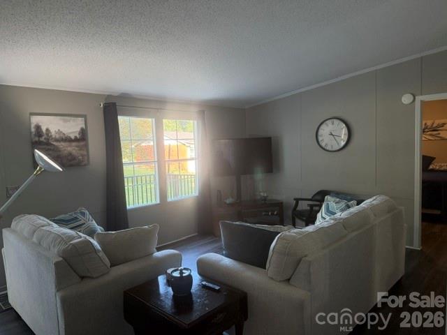 Living room with two sofas, a dark coffee table, and windows overlooking a deck.
