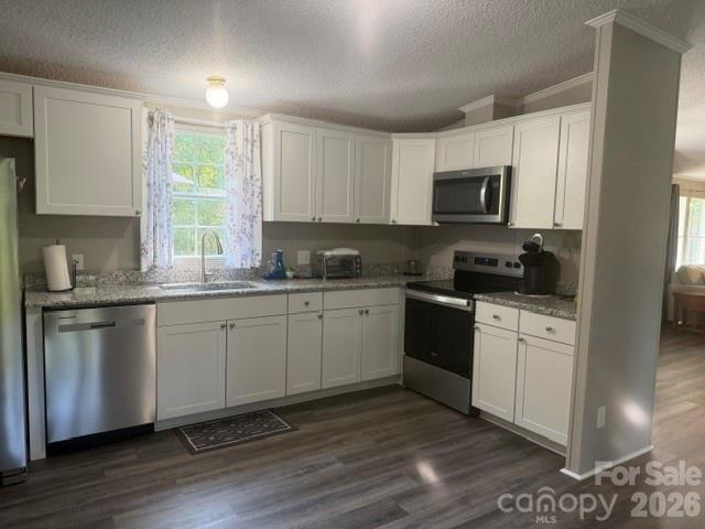 Kitchen with white cabinets, dark countertops, and stainless steel appliances.