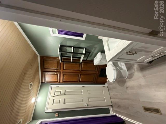 Bathroom with dark wood built-in cabinets, green walls, and a light wood ceiling.