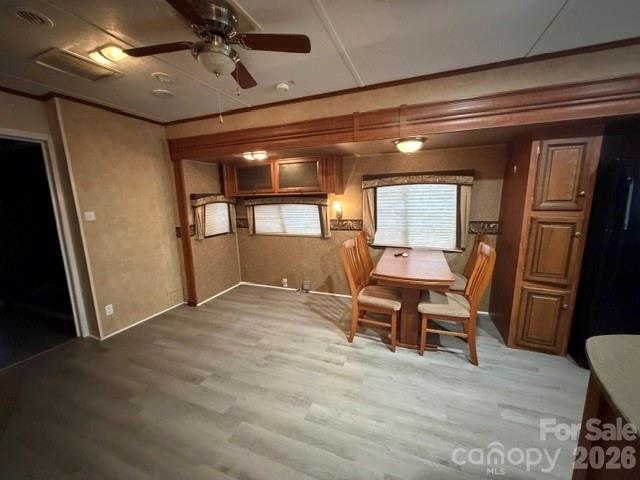 Dining area with a wooden table, built-in cabinetry, and gray plank flooring.
