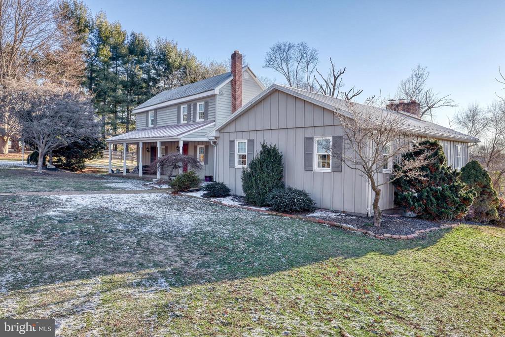 Light gray two-story house with a covered porch and lightly frosted lawn.