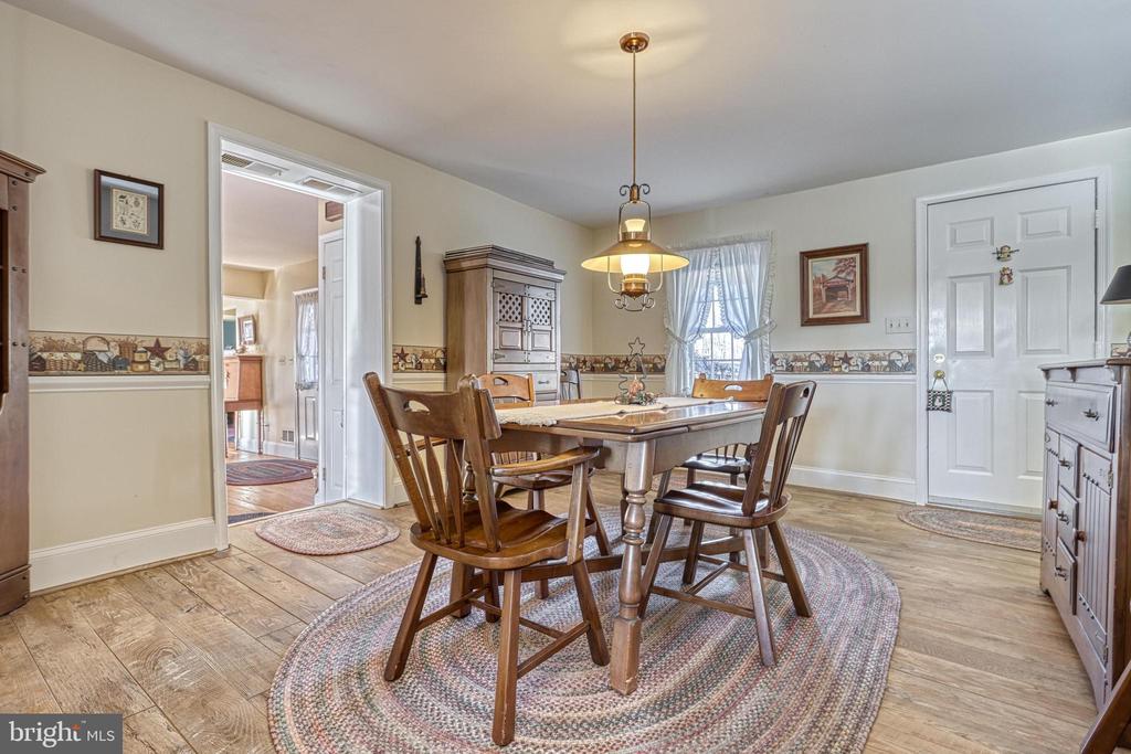 Dining room with a wooden table and chairs, china cabinet, and wide plank flooring.