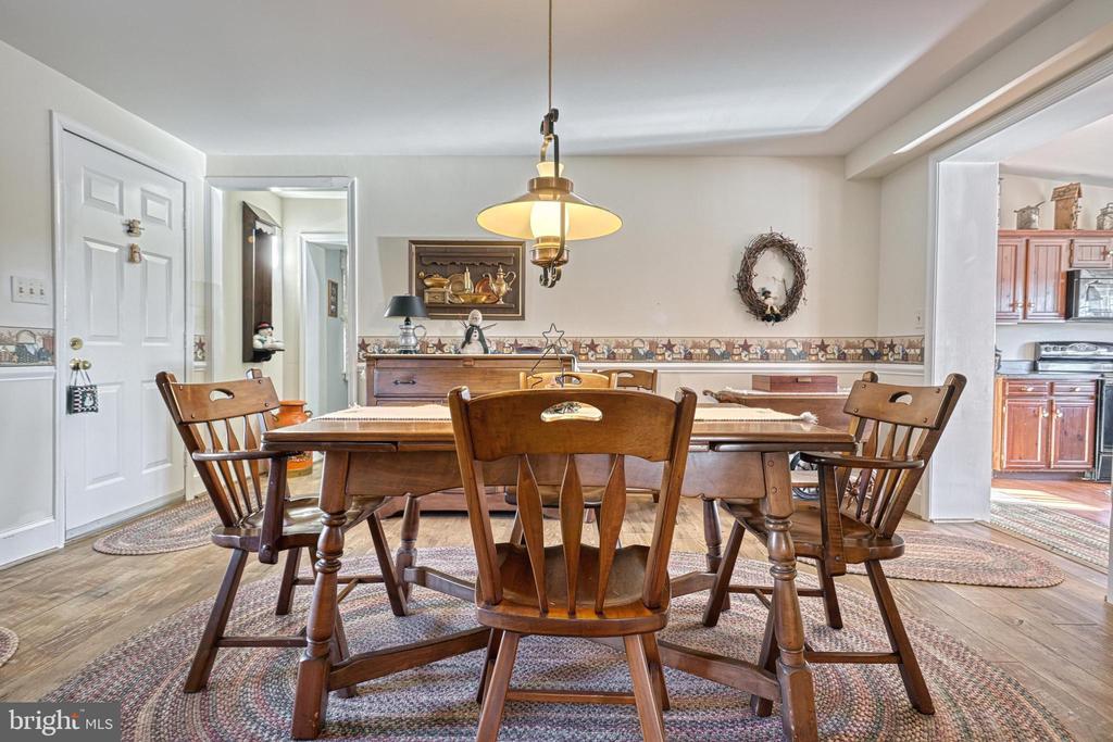 Dining room with a wooden table and chairs, pendant light, and doorway to the kitchen.
