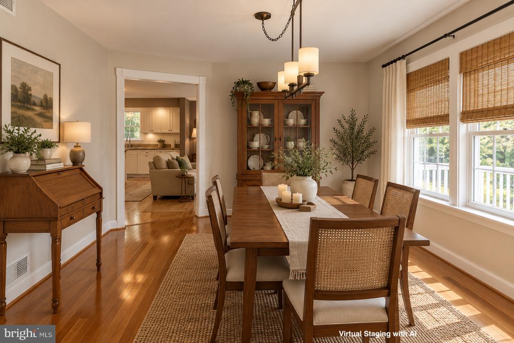 Dining room with a wooden table, woven-back chairs, and sunlight streaming through windows with woven shades.