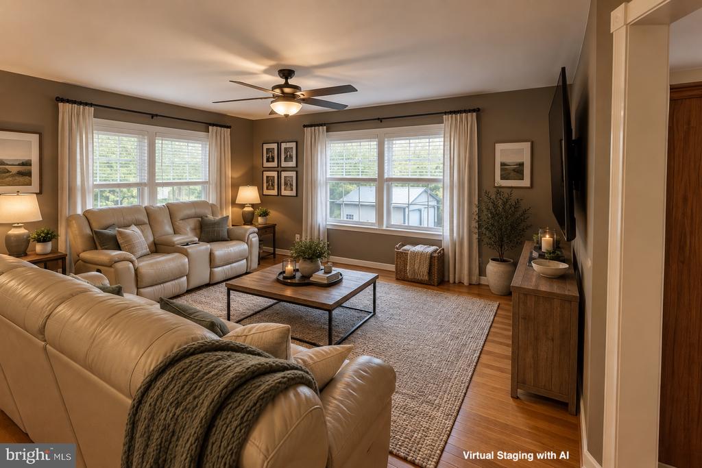 Virtually staged living room with beige sofas, wood floors, and large curtained windows.