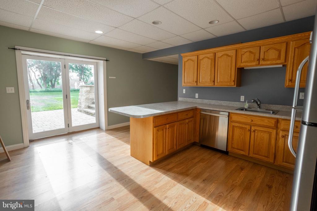 Kitchen with wood cabinets and peninsula beside sliding glass doors to a patio.