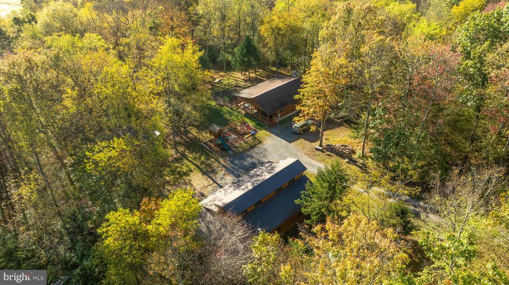 Aerial view of two buildings and a playground surrounded by autumn trees.