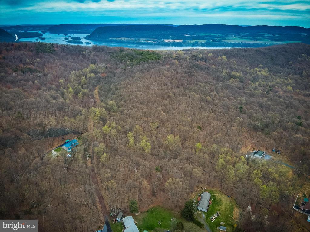 Wooded property with scattered homes and distant water, seen from above.