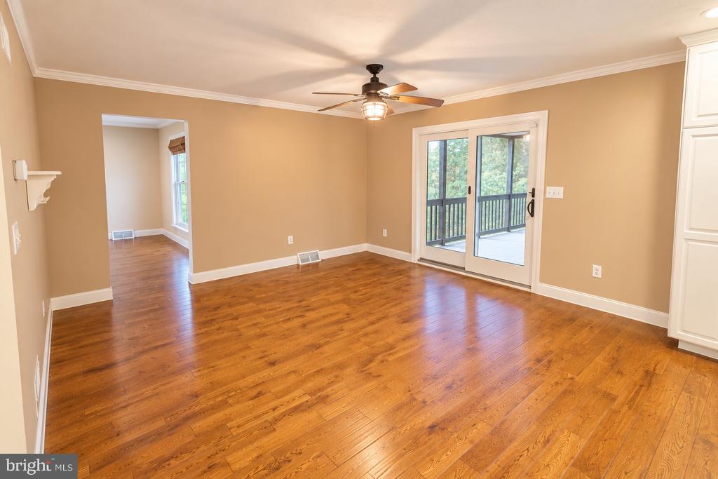 Empty dining room with hardwood floors, a ceiling fan, and sliding doors to a deck.