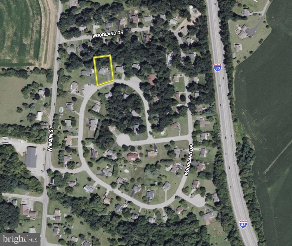 Aerial view of the home at 73 Woodland Drive, outlined in yellow beside a residential cul-de-sac.