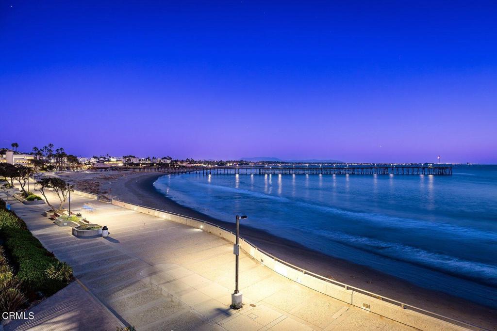 Beachfront promenade and pier beside the ocean at twilight.