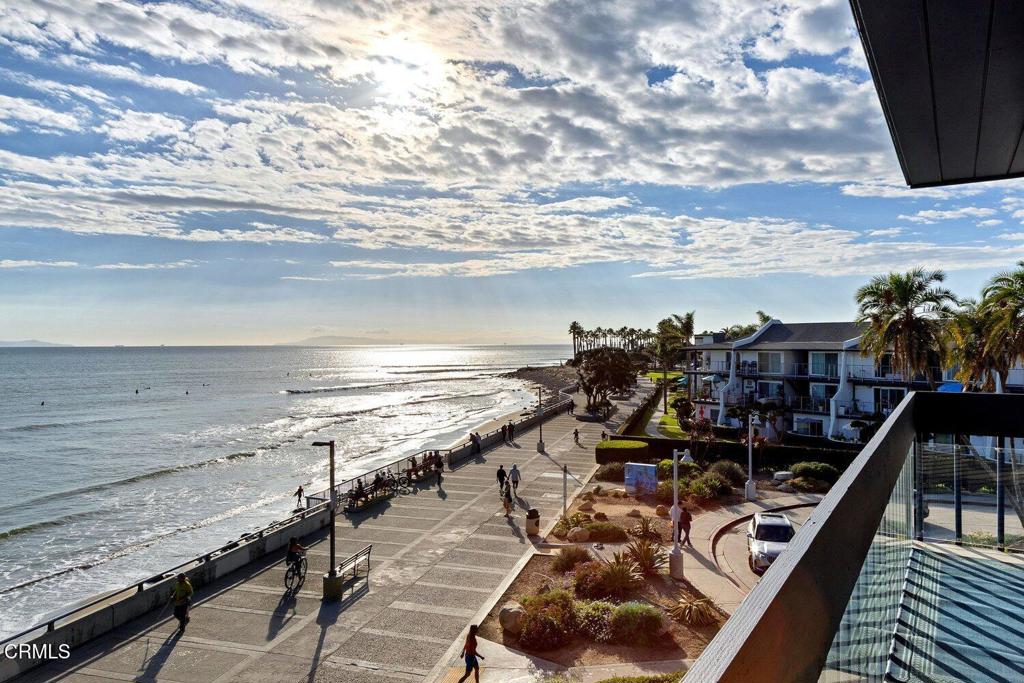 Oceanfront promenade and Pacific waves viewed from a balcony.