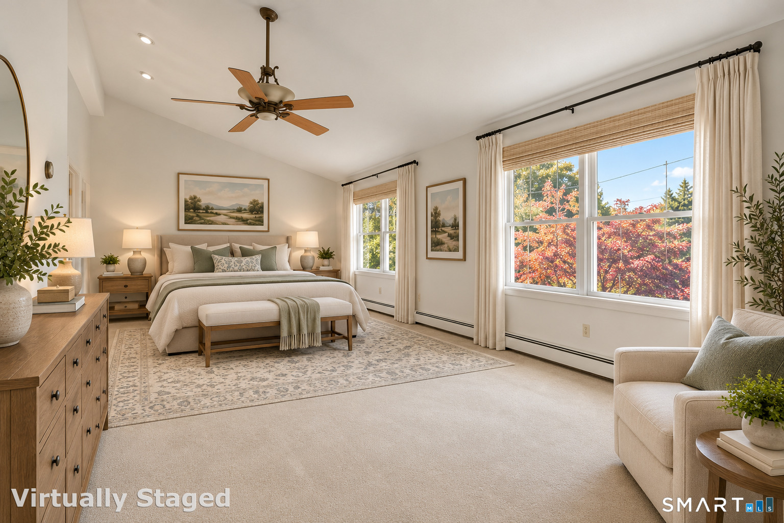 Virtually staged bedroom with a king bed, ceiling fan, and large windows overlooking autumn trees.