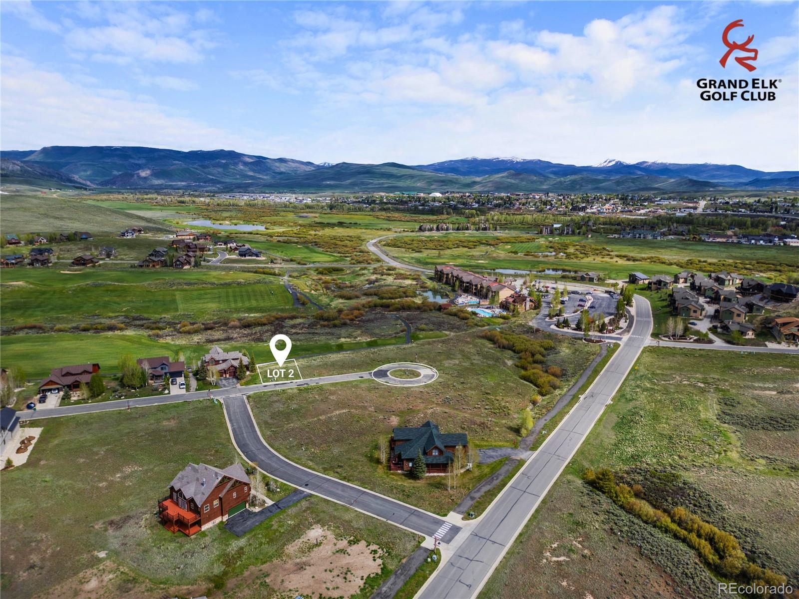 Aerial view of vacant Lot 2 beside a cul-de-sac, with Grand Elk golf course terrain and mountains beyond.
