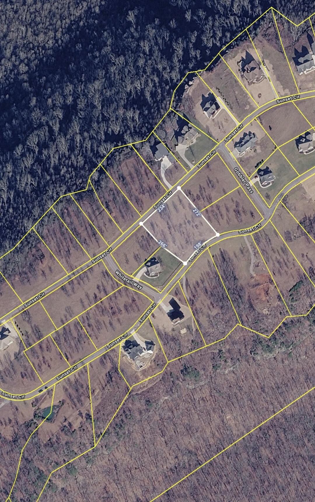 Aerial parcel map showing a wooded lot on Sunset Circle outlined with white boundary lines.