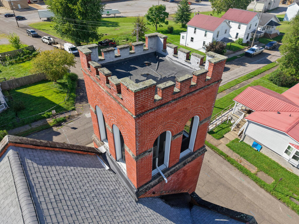 Aerial view of a red-brick building with crenellated parapets and arched windows.