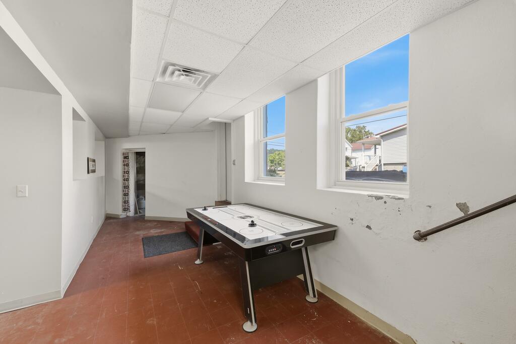 Recreation room with an air hockey table and two large windows.