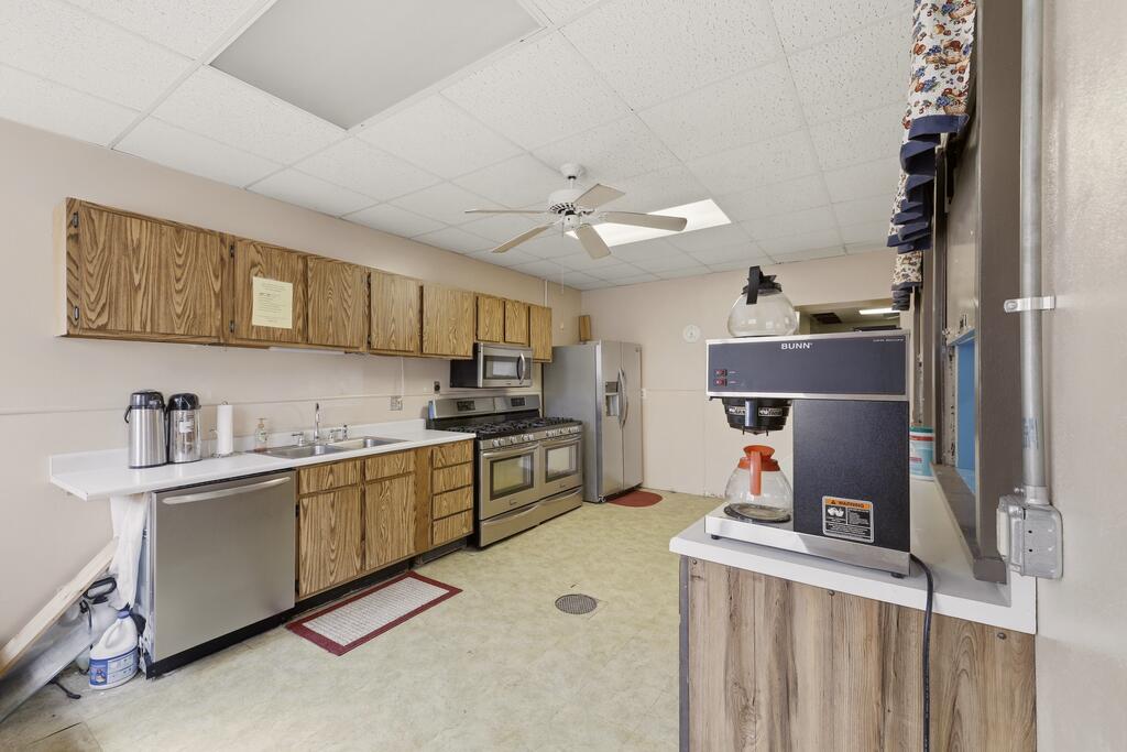 Kitchen with wood-grain cabinets, stainless-steel appliances, and a large BUNN coffee brewer.