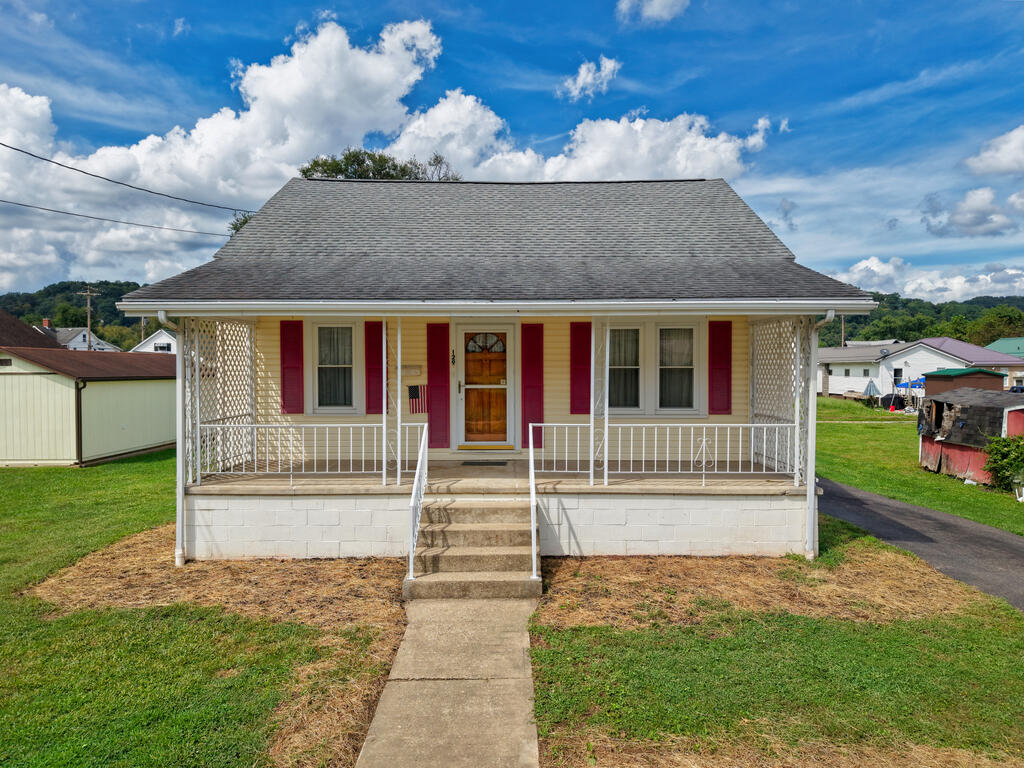 Single-story house with red shutters, a covered porch, and concrete walkway to the front door.