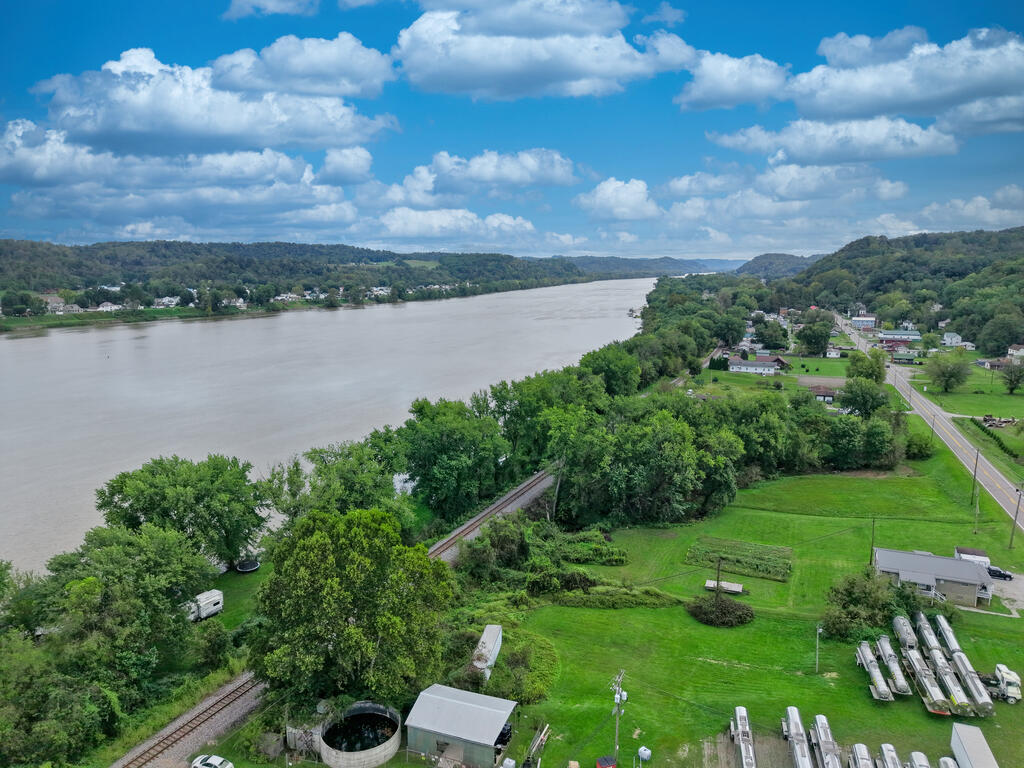 Aerial view of a river and green riverfront land beside a small town and railway.