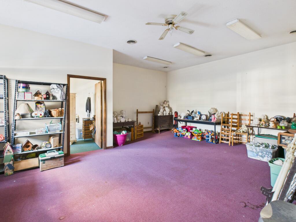Large purple-carpeted room with toys and shelving along the walls.