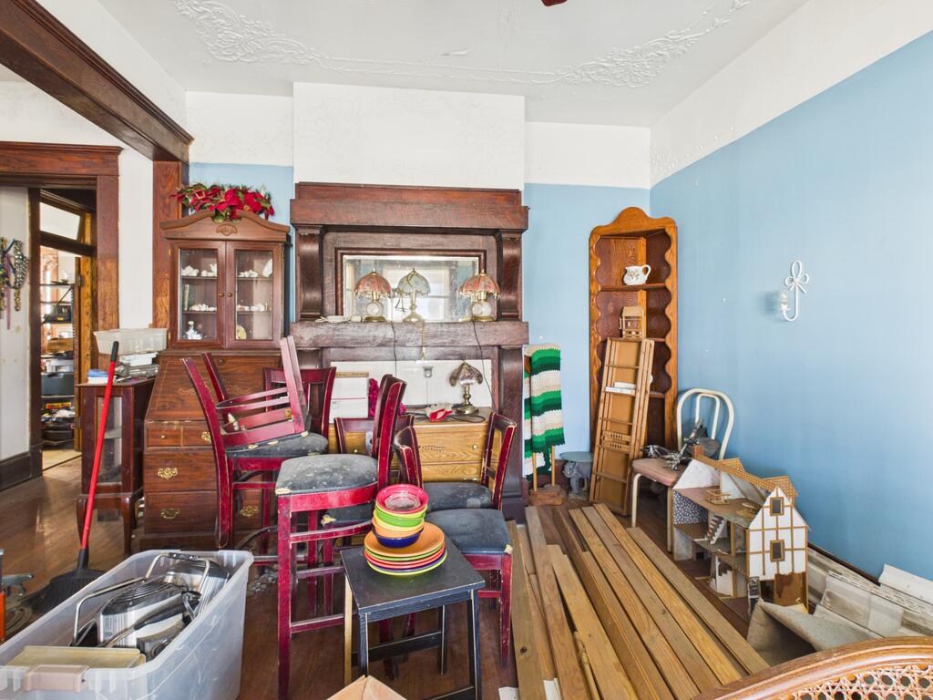 Furnished room with blue walls, ornate ceiling molding, and a large dark wood mantel.