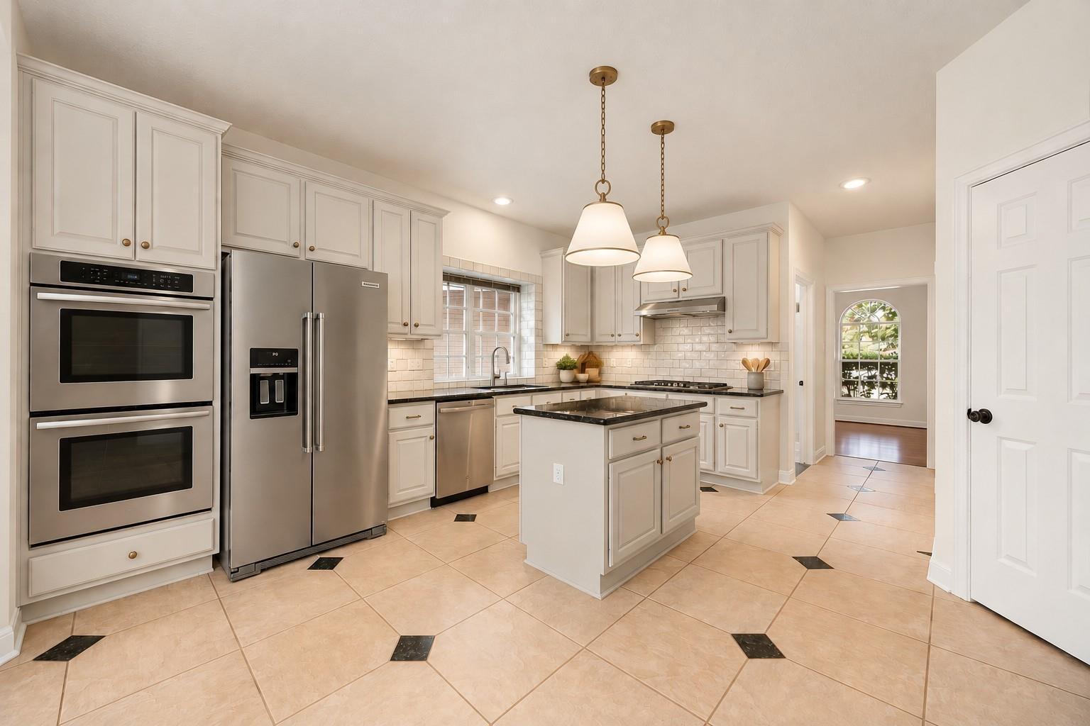 Kitchen with white cabinets, stainless steel appliances, and a central island.