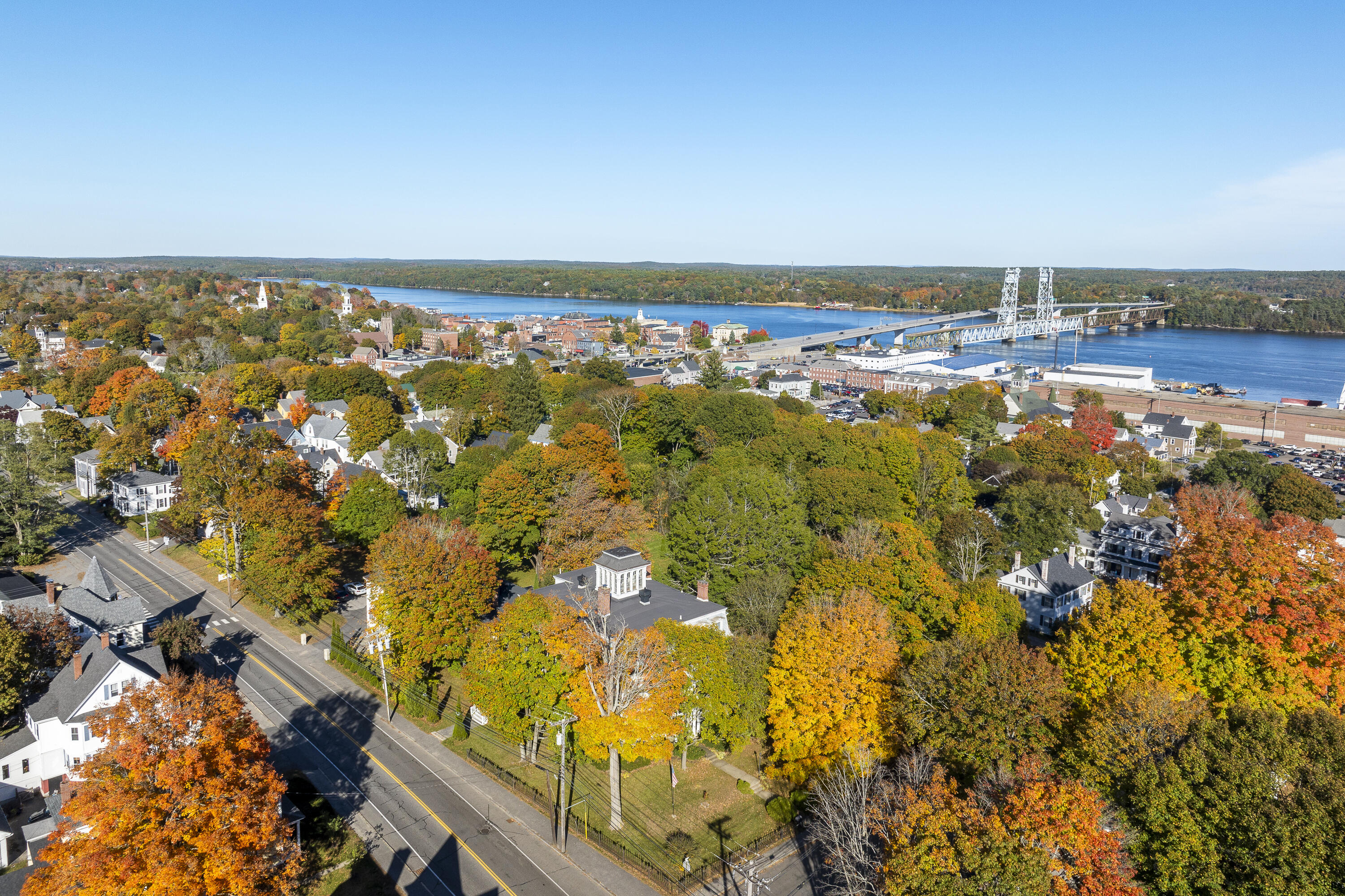 Aerial view of Bath’s autumn-colored streets, the Kennebec River, and the bridge.
