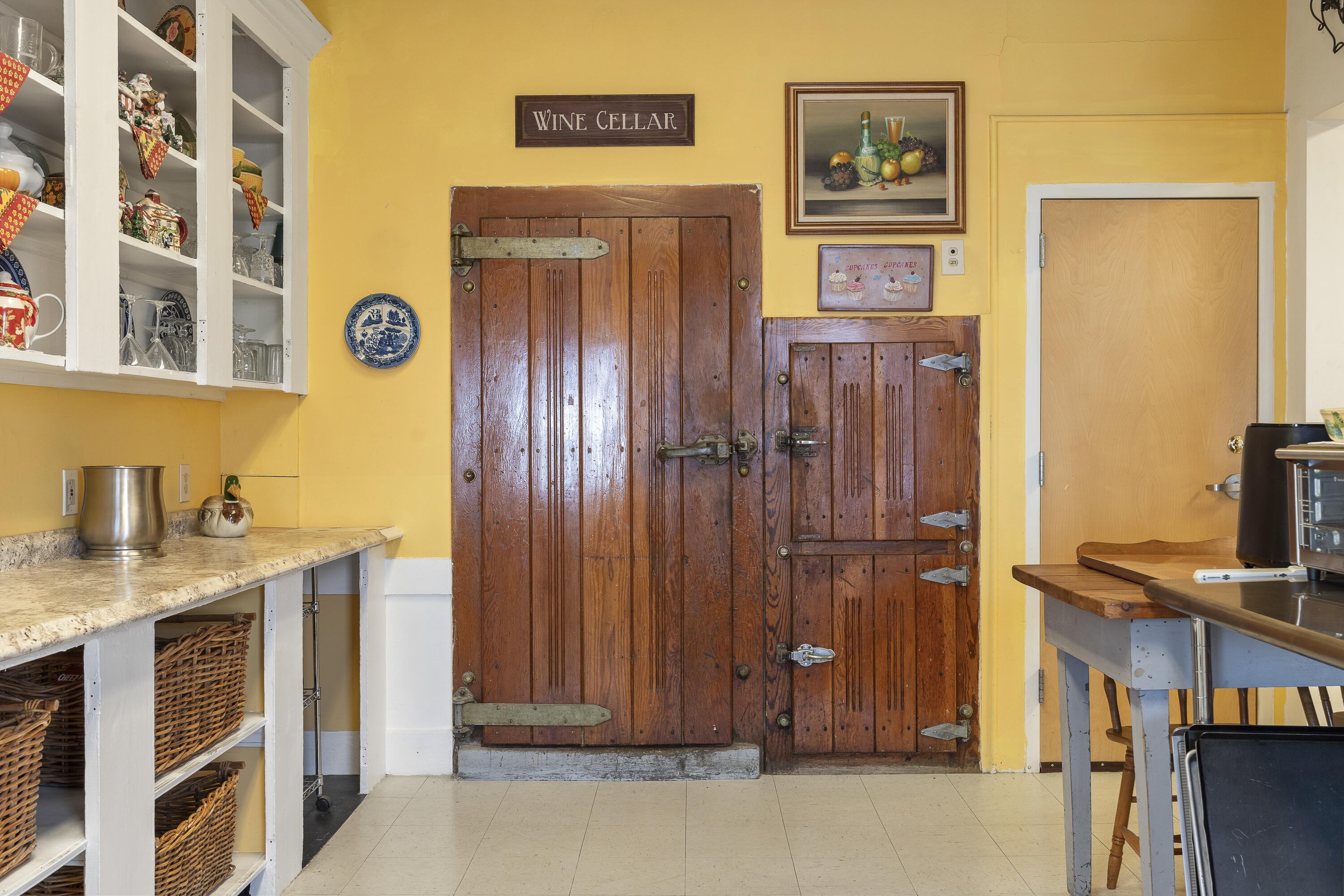 Kitchen with bright yellow walls and rustic wooden wine cellar doors.