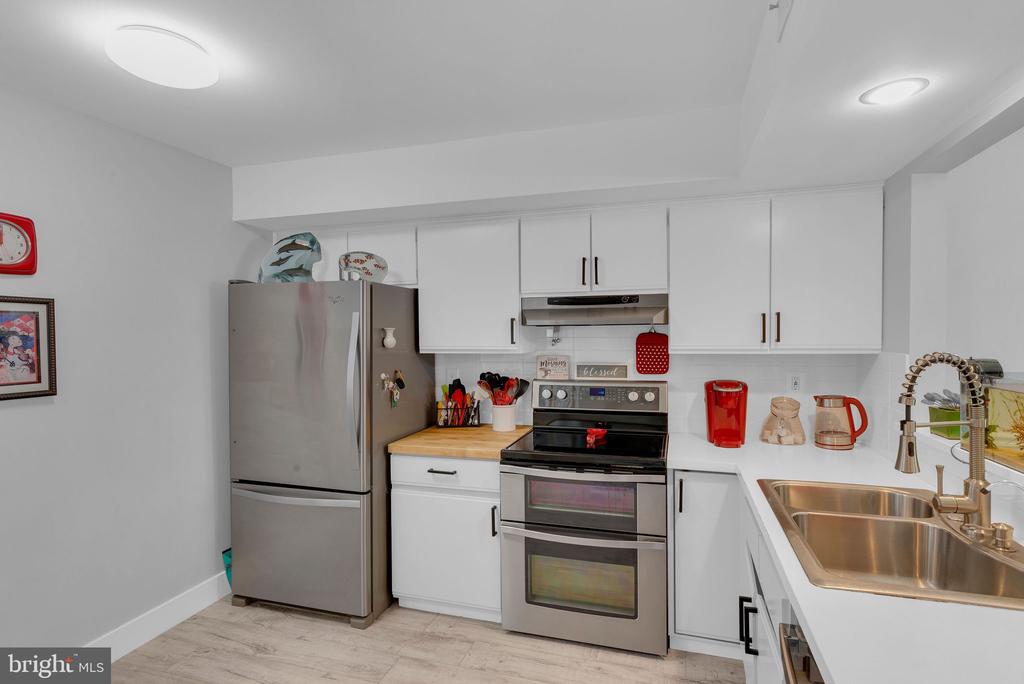 Kitchen with white cabinets, stainless steel appliances, and a double-basin sink.