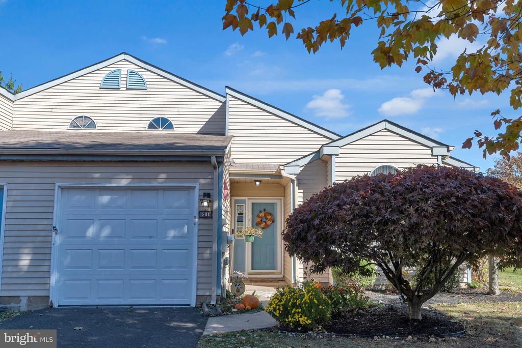 Front exterior of a beige-sided home with a blue garage door and covered entry.
