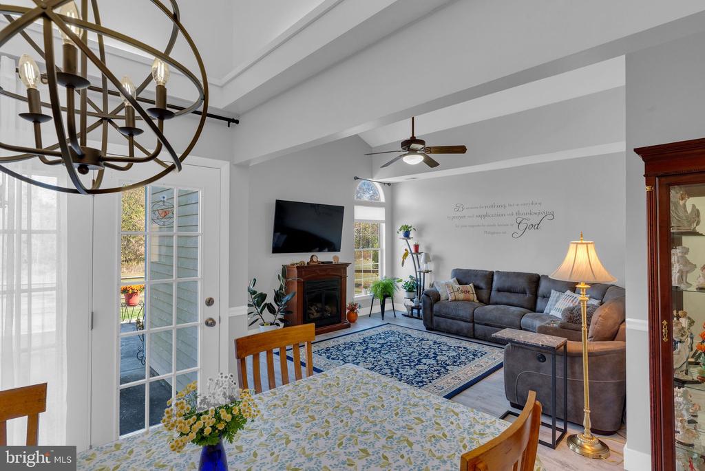 Open living and dining room with a gray sectional, fireplace, and blue patterned rug.