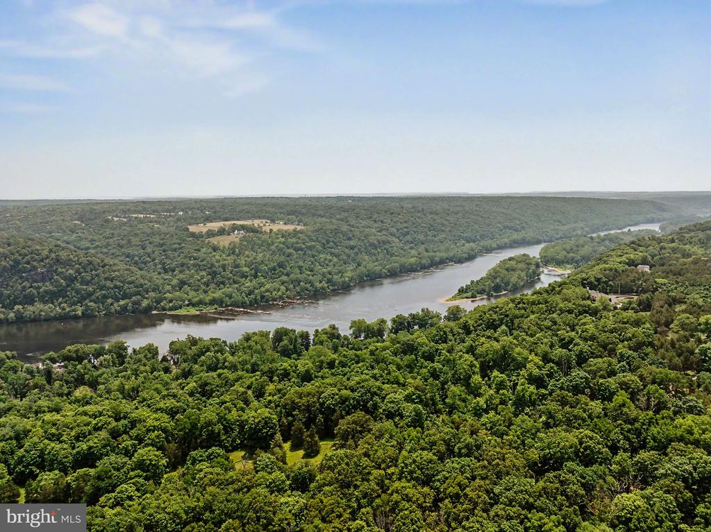 Aerial view of wooded hills surrounding a broad, winding river.