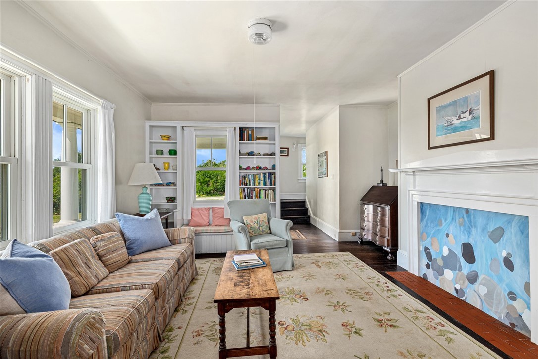 Living room with a striped sofa, built-in shelves, and a fireplace with a blue-tiled surround.