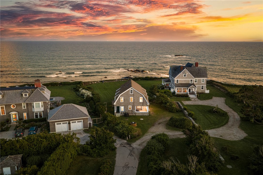 Aerial view of 5 Kempton Place beside the ocean, with neighboring homes and a colorful sunset.