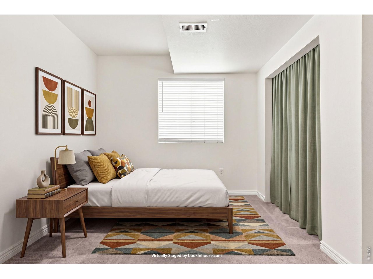 Bedroom with a wooden bed, geometric rug, abstract prints, and green curtains.