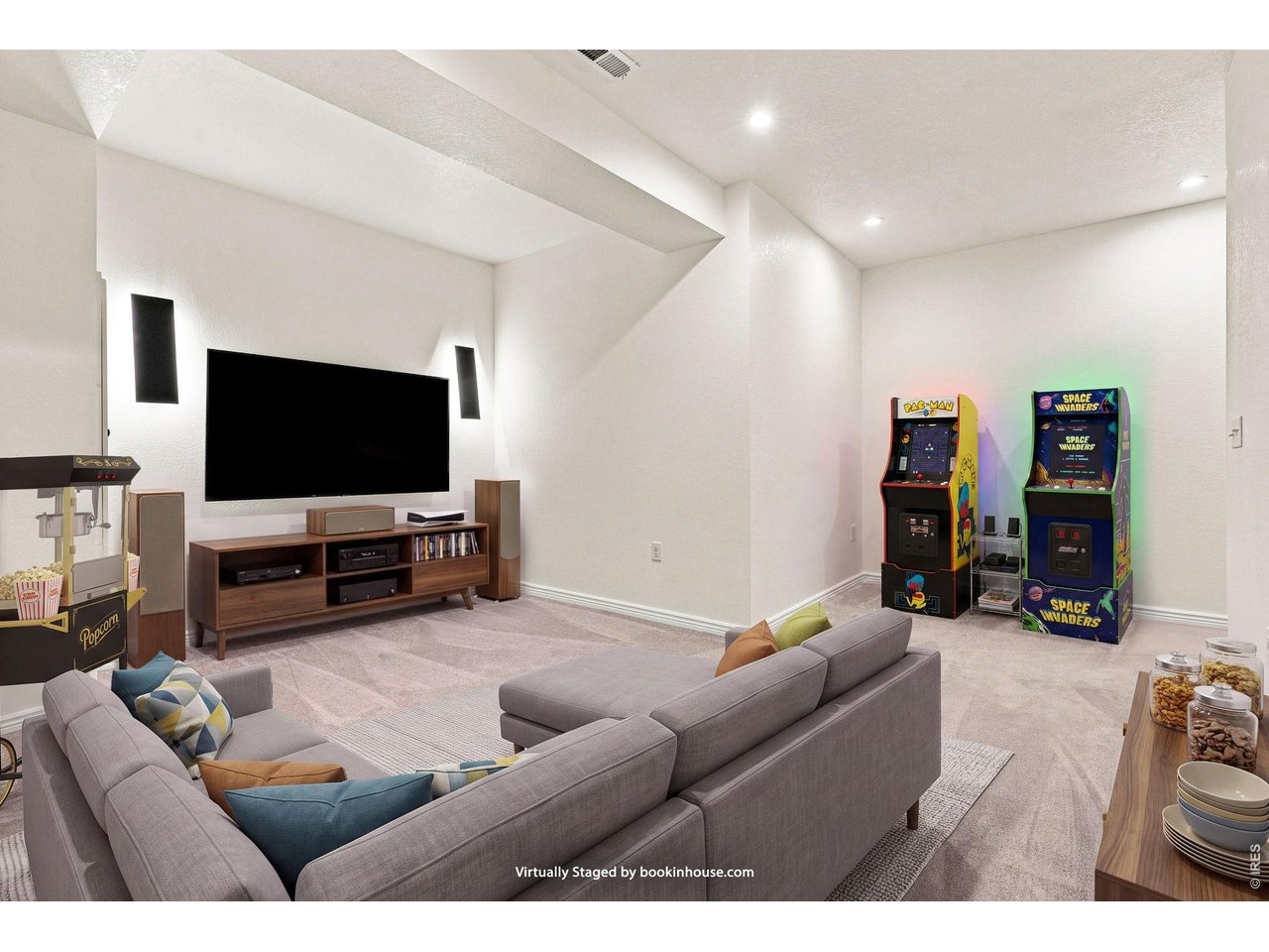 Virtually staged game room with a home theater, arcade cabinets, and popcorn machine.