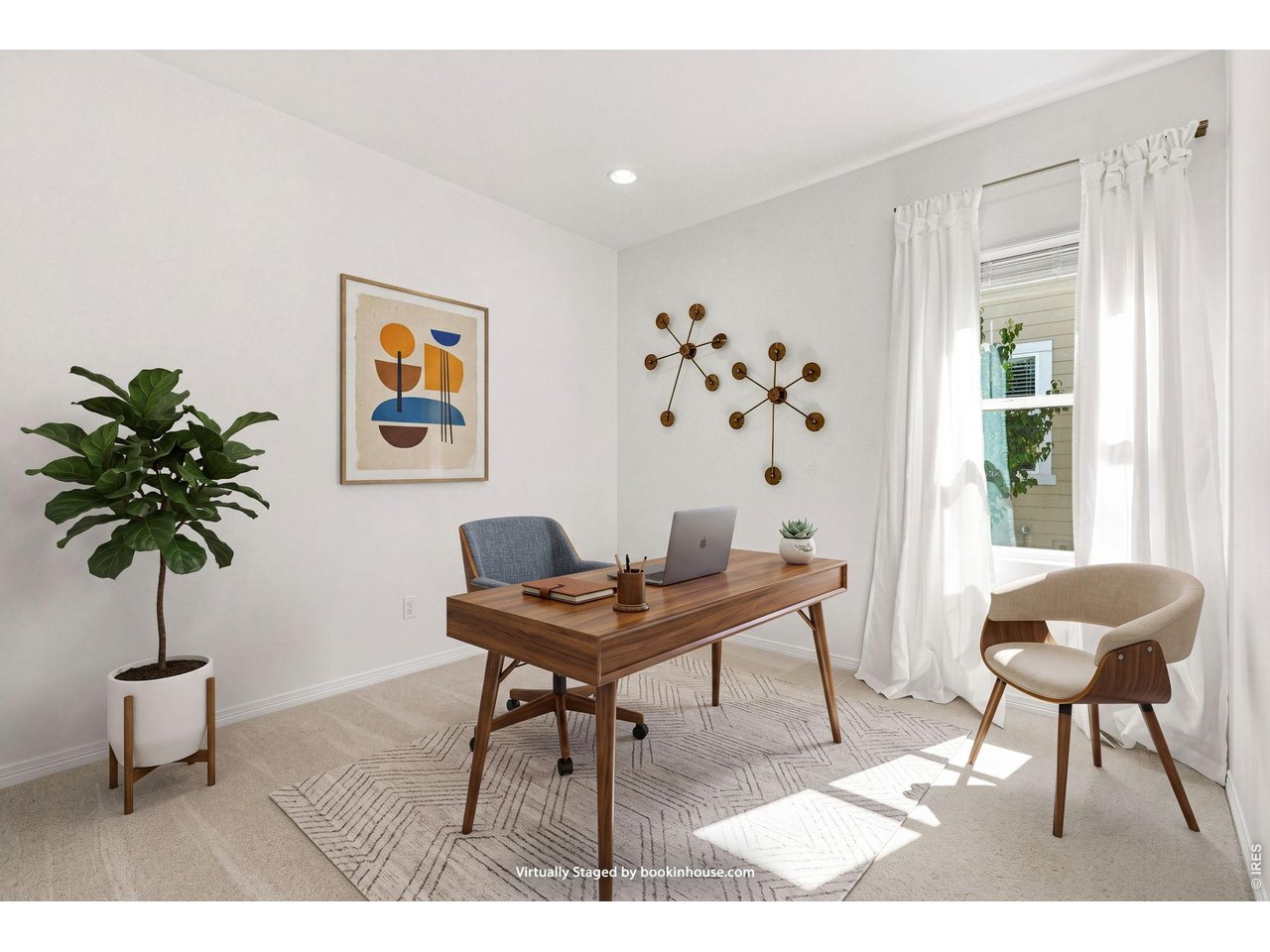Virtually staged home office with a walnut desk, laptop, and bright curtained windows.