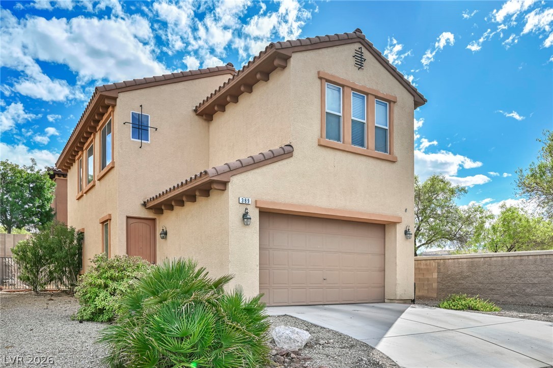Two-story stucco home with a tiled roof, two-car garage, and desert landscaping.