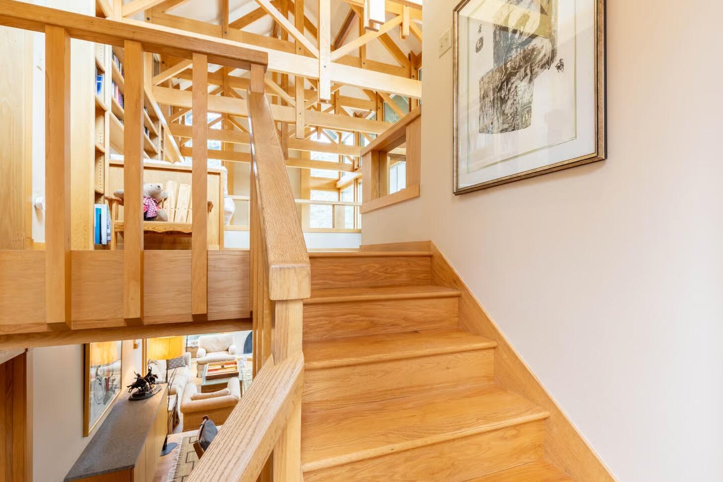 Wooden staircase ascending to an open timber-framed landing above the living area.